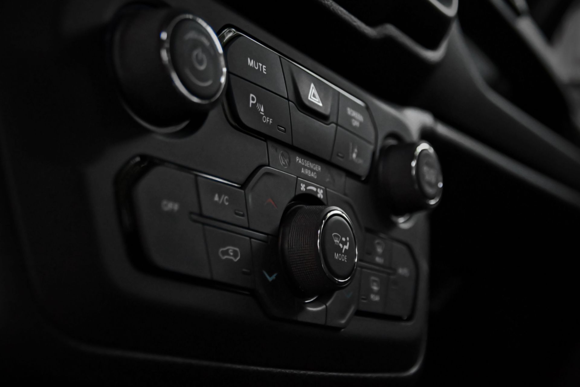 Detailed close-up of a car's control panel featuring various buttons and switches for functionality.
